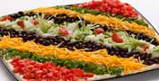 Southwest fiesta dip with layers of beans, cheese, and toppings